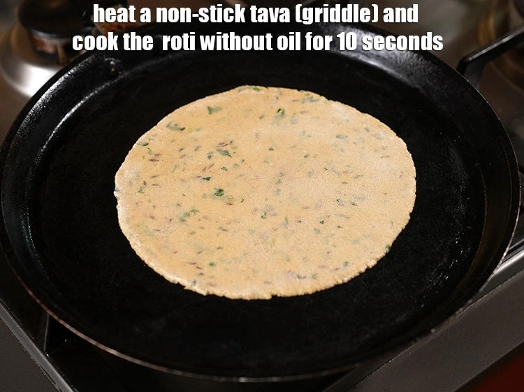 Step 17 – <p>Heat a non-stick tava (griddle) and cook the &nbsp;<strong>roti </strong>without oil for 10 seconds.</p>
