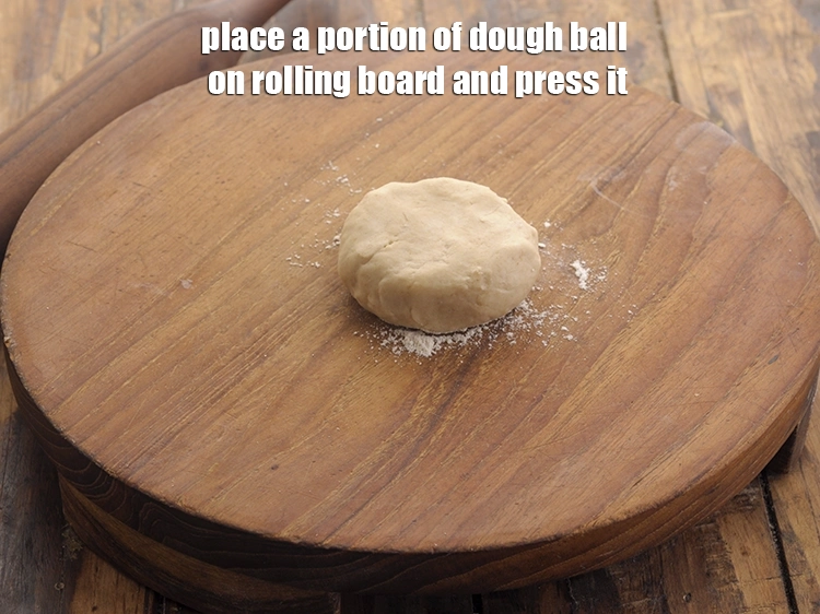 Step 24 – <p>Place a portion of <strong>dough ball</strong> on rolling board and <strong>press it.</strong></p>