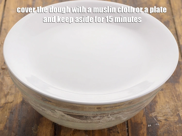 Step 10 – <p>Cover the dough with a muslin cloth or a plate and keep aside for 15 …