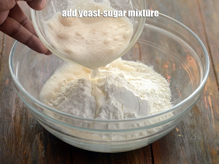 Step 9 – <p>Add <strong>yeast-sugar mixture</strong>. Many people including Jains do not prefer using yeast. Baking powder along …