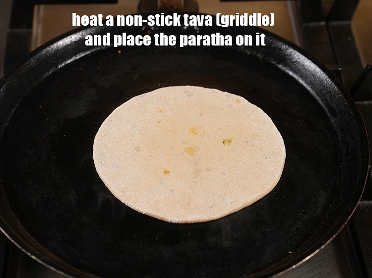 Step 48 – <p><span style="background-color:rgb(255,255,255);color:rgb(0,0,0);">Heat a non-stick tava (griddle) and place the <strong>paratha</strong> on it.</span></p>