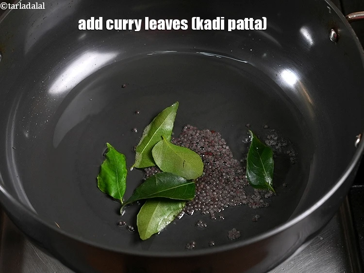 Step 25 – <p>When the seeds crackle, add the <span style="background-color:rgb(255,255,255);color:rgb(0,0,0);">6 </span><a href="https://www.tarladalal.com/glossary-curry-leaves-kadi-patta-kadipatta-388i"><u>curry leaves (kadi patta)</u></a>.</p>