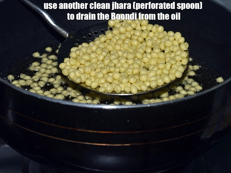 Step 14 – <p>Use another clean jhara (perforated spoon) to drain the<strong>&nbsp;Boondi</strong>&nbsp;from the oil.</p>