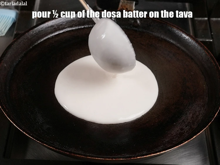 Step 17 – <p><span style="color:rgb(0,0,0);">Pour ½ cup of the <strong>dosa batter</strong> on the tava. This is approximately 2 …