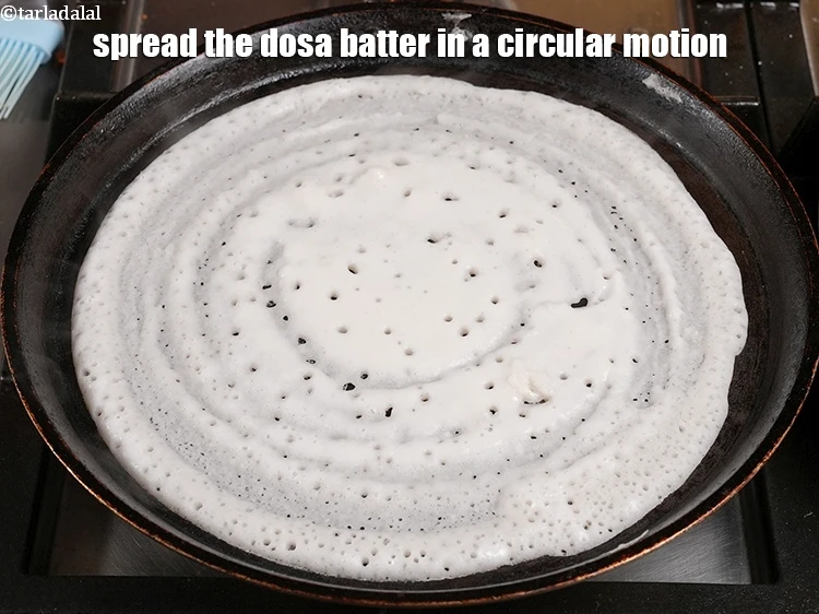 Step 18 – <p><span style="color:rgb(0,0,0);">Spread the <strong>dosa batter</strong> in a circular motion using a ladle to make a …