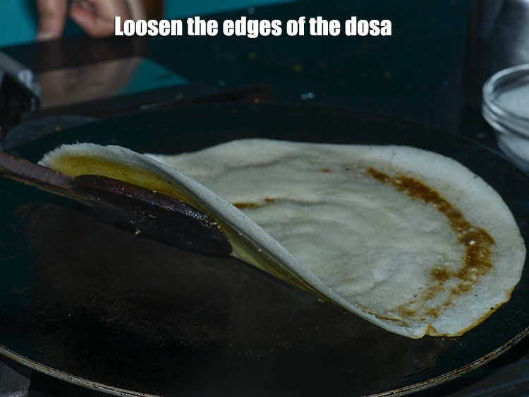 Step 20 – <p><span style="color:rgb(0,0,0);"><strong>Loosen</strong> the edges of the <strong>dosa</strong>. This will help in <strong>folding the dosa</strong> once …