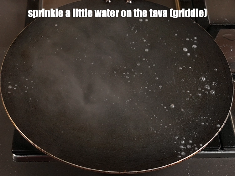 Step 20 – <p><span style="background-color:rgb(255,255,255);color:rgb(0,0,0);">Sprinkle a <strong>little</strong> <strong>water</strong> on the tava (griddle).</span></p>