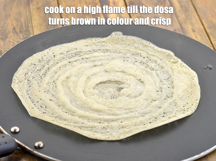 Step 33 – <p><span style="background-color:rgb(255,255,255);color:rgb(0,0,0);">Cook on a high flame till the <strong>dosa</strong> turns brown in colour and crisp.</span></p>