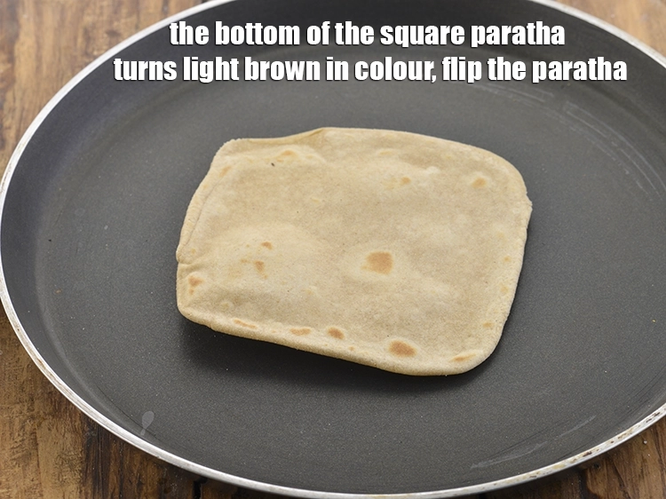 Step 36 – <p>The bottom of the<strong> square paratha</strong> turns light brown in colour, flip the <strong>paratha.</strong></p>