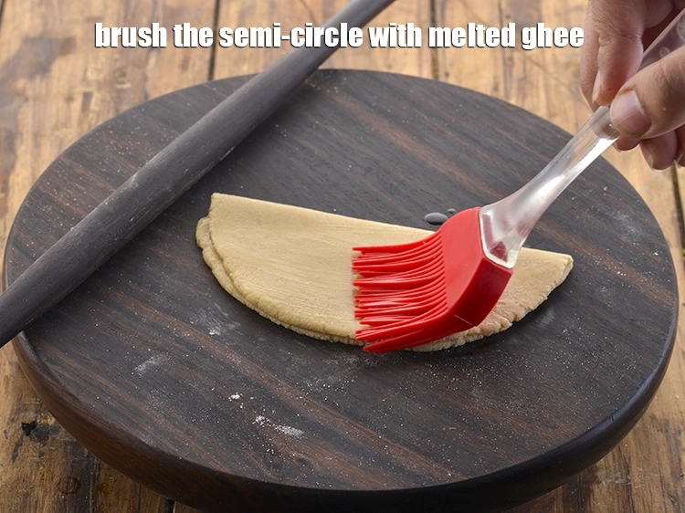 Step 16 – <p>Brush the semi-circle with melted <a href="https://www.tarladalal.com/glossary-ghee-245i"><u>ghee</u></a>.</p>