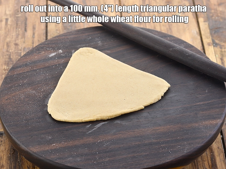Step 18 – <p>Roll out into a 100 mm. (4") length triangular <strong>paratha</strong> using a little whole wheat …