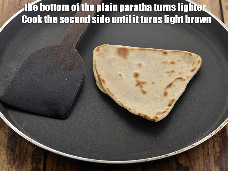 Step 20 – <p>The bottom of the&nbsp;<strong>plain paratha</strong>&nbsp;turns lighter, flip the paratha.</p>