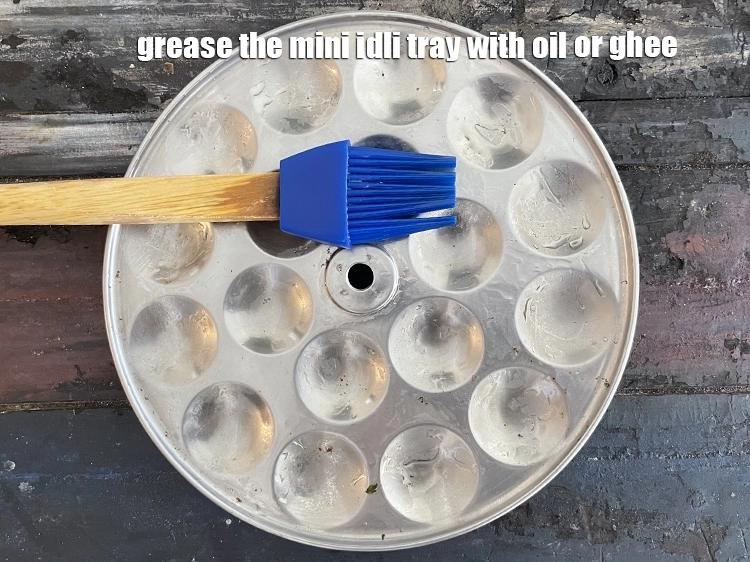 Step 3 – <p>Grease the mini idli tray with <a href="https://www.tarladalal.com/glossary-ghee-245i"><u>ghee</u></a><u> or </u>oil. <span style="background-color:rgb(255,255,255);color:rgb(0,0,0);">Put a little </span><a …