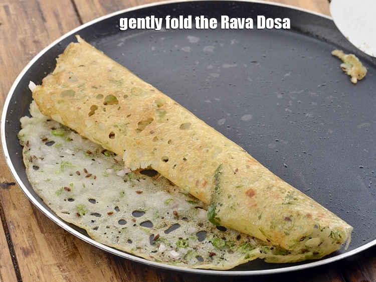 Step 23 – <p>Gently fold the <strong>Rava Dosa </strong>over with the help of a flat spoon to make …