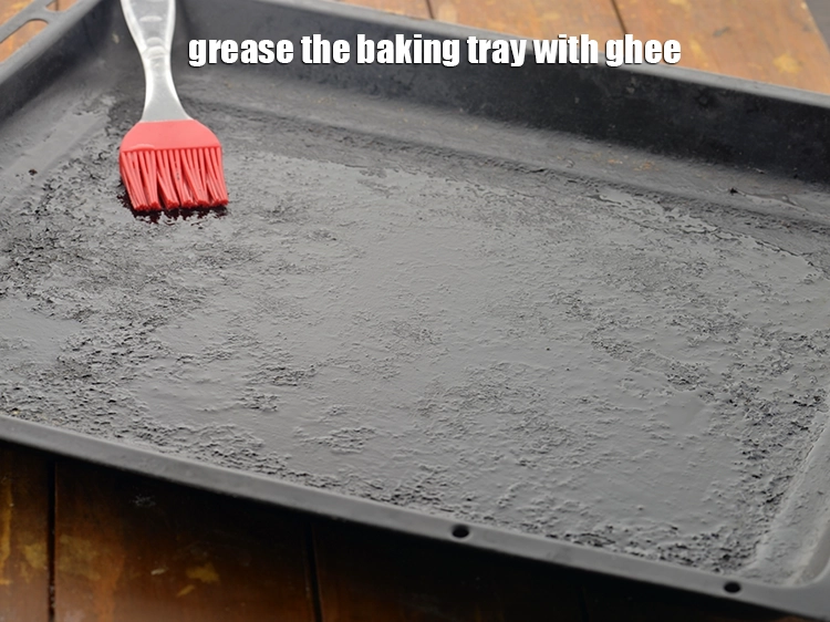 Step 15 – <p>Grease a baking tray with <a href="https://www.tarladalal.com/glossary-ghee-245i"><u>ghee</u></a>. You can even use 1tsp <strong>oil</strong> greasing.</p>