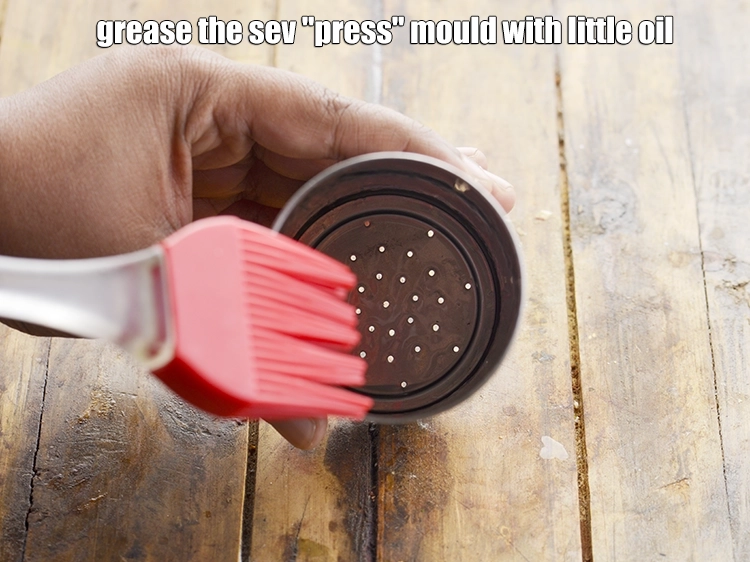 Step 2 – <p><span style="background-color:rgb(255,255,255);color:rgb(0,0,0);">Grease the <strong>sev "press" mould</strong> with little </span><a href="https://www.tarladalal.com/glossary-oil-671i"><u>oil</u></a><span style="background-color:rgb(255,255,255);color:rgb(0,0,0);">.</span></p>