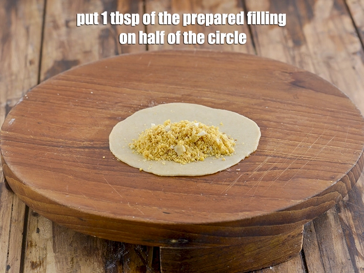 Step 15 – <p><span style="background-color:rgb(255,255,255);color:rgb(0,0,0);">Put 1 tbsp. of the <strong>prepared filling</strong> on half of the circle.</span></p>