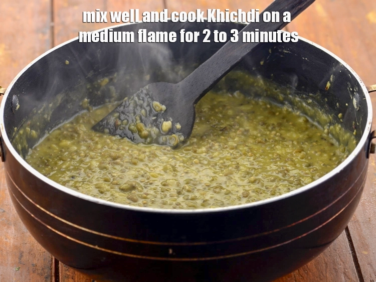 Step 21 – <p>Mix well and cook <strong>Bajra Khichdi with Green Moong Dal</strong> on a medium flame for …