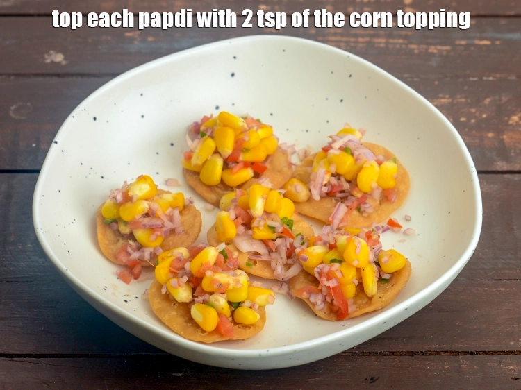 Step 26 – <p><span style="background-color:rgb(255,255,255);color:rgb(0,0,0);">Top each papdi with 2 tsp of the <strong>corn topping</strong>.</span></p>