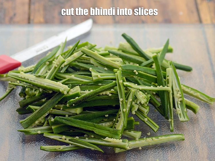 Step 6 – <p><span style="background-color:rgb(255,255,255);color:rgb(0,0,0);">Cut the <strong>bhindi into slices</strong>. Basically each bhindi is cut into 4 parts vertically.</span></p>
