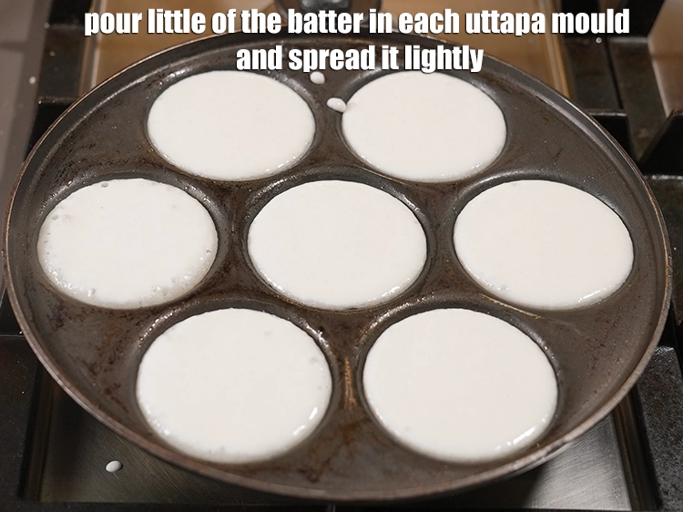 Step 7 – <p><span style="background-color:rgb(255,255,255);color:rgb(0,0,0);">Pour little of the <strong>batter</strong> in each uttapa mould and <strong>spread</strong> it lightly.</span></p>