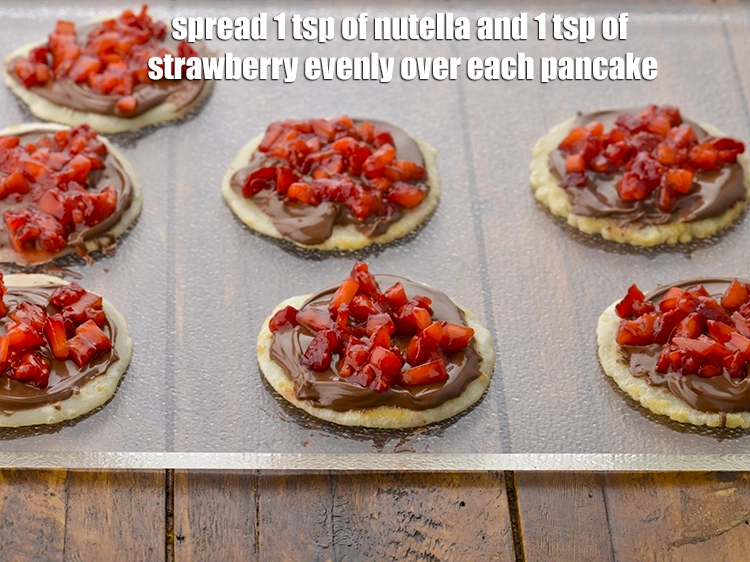 Step 10 – <p><span style="background-color:rgb(255,255,255);color:rgb(0,0,0);">Place the <strong>pancakes</strong> on a clean, dry surface, spread 1 tsp of </span><a href="https://www.tarladalal.com/glossary-nutella-1288i"><u>nutella …