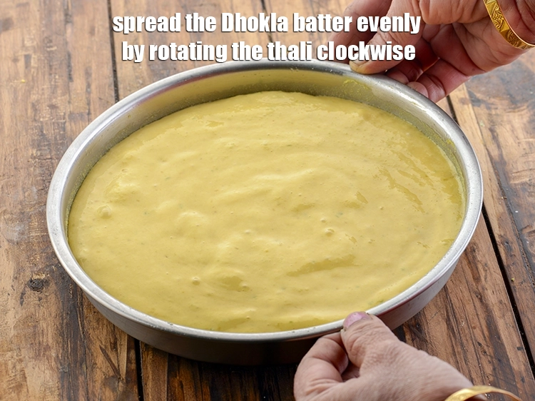 Step 14 – <p>Spread the <strong>Khaman Dhokla batter </strong>evenly by rotating the thali clockwise.</p>