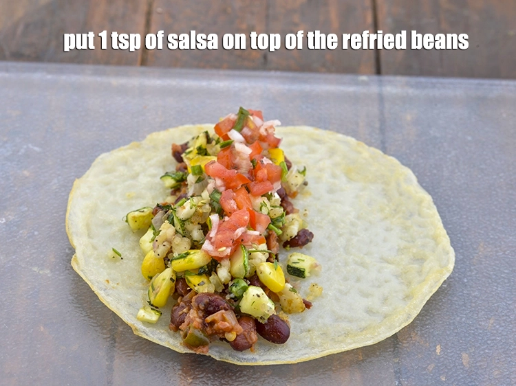 Step 11 – <p><span style="background-color:rgb(255,255,255);color:rgb(0,0,0);">Put 1 tsp of </span><a href="https://www.tarladalal.com/uncooked-salsa-raw-tomato-salsa-41332r"><u>uncooked salsa</u></a><span style="background-color:rgb(255,255,255);color:rgb(0,0,0);"> on top of the refried beans.</span></p>