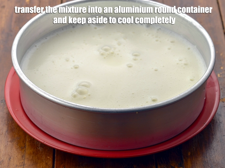 Step 7 – <p><span style="background-color:rgb(255,255,255);color:rgb(0,0,0);">Transfer the mixture into an aluminium round container and keep aside to <strong>cool completely</strong>.</span></p>
