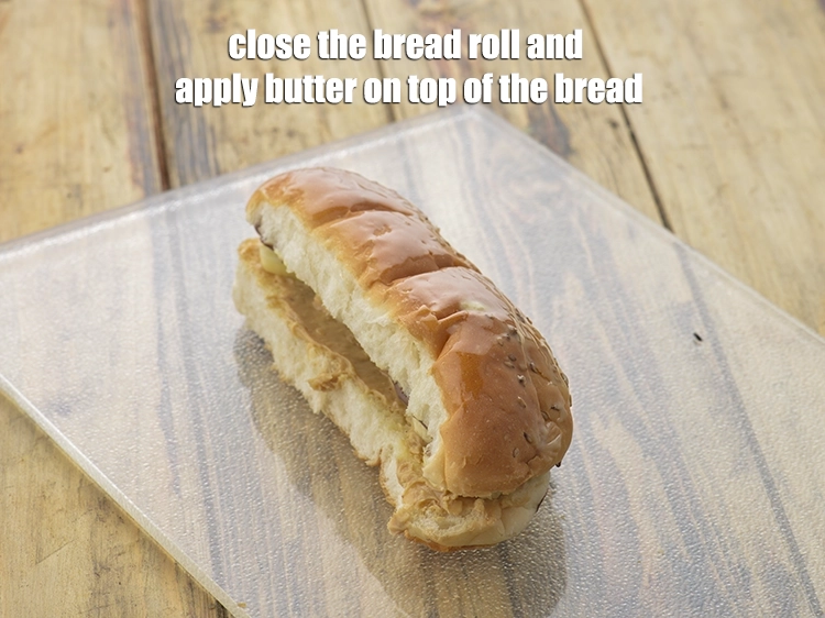 Step 7 – <p><span style="background-color:rgb(255,255,255);color:rgb(0,0,0);">Close the <strong>bread roll </strong>and apply ½ tsp of </span><a href="https://www.tarladalal.com/glossary-butter-makhan-233i"><u>butter</u></a><span style="background-color:rgb(255,255,255);color:rgb(0,0,0);"> on top …