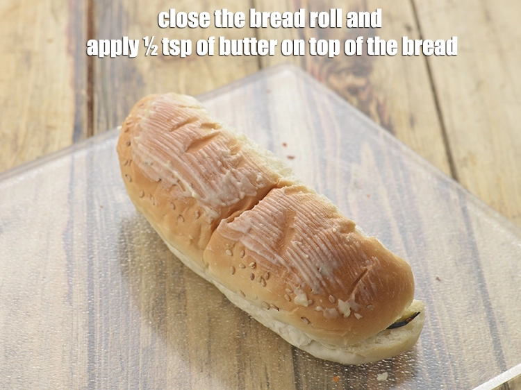 Step 12 – <p><span style="background-color:rgb(255,255,255);color:rgb(0,0,0);">Close the <strong>bread roll</strong> and apply ½ tsp of </span><a href="https://www.tarladalal.com/glossary-butter-makhan-233i"><u>butter</u></a><span style="background-color:rgb(255,255,255);color:rgb(0,0,0);"> on top …