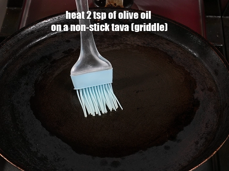 Step 4 – <p><span style="background-color:rgb(255,255,255);color:rgb(0,0,0);">Heat 2 tsp of </span><a href="https://www.tarladalal.com/glossary-olive-oil-451i"><u>olive oil</u></a><span style="background-color:rgb(255,255,255);color:rgb(0,0,0);"> on a non-stick tava (griddle).</span></p>
