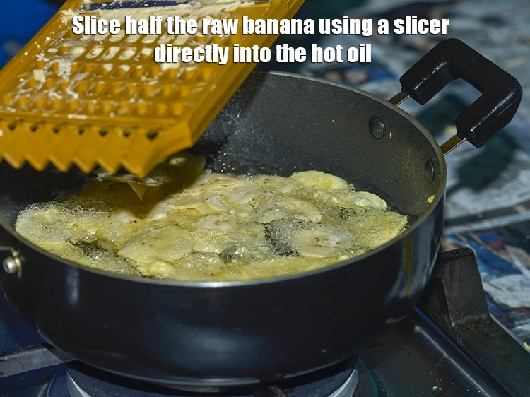 Step 6 – <p><span style="background-color:rgb(255,255,255);color:rgb(0,0,0);">Slice half the <strong>raw banana </strong>using a slicer directly into the hot oil.</span></p>