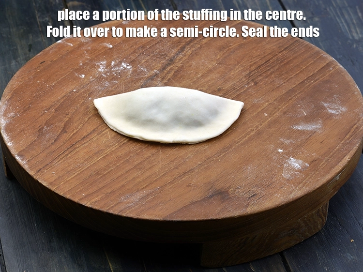 Step 15 – <p><span style="background-color:rgb(255,255,255);color:rgb(0,0,0);">Place a portion of the <strong>stuffing</strong> in the centre. <strong>Fold</strong> it over to make …