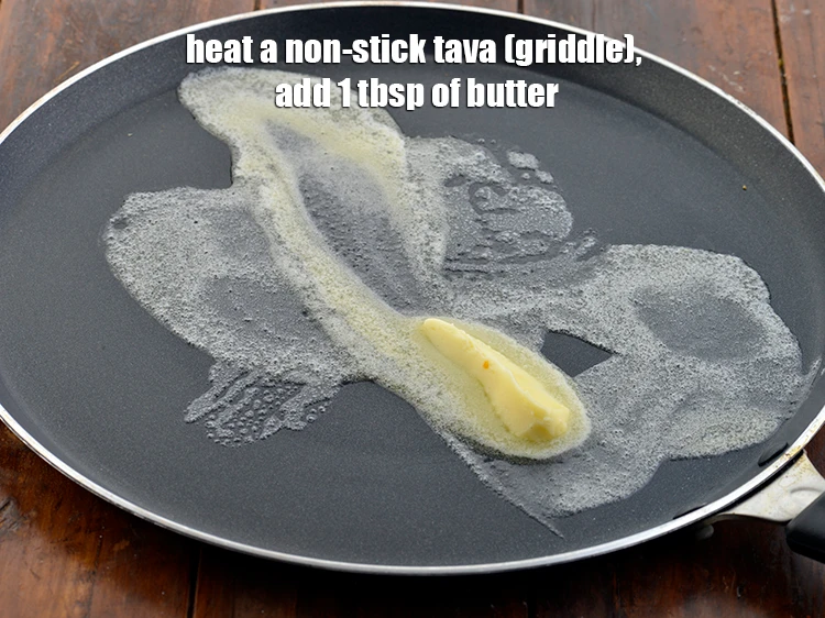 Step 12 – <p><span style="background-color:rgb(255,255,255);color:rgb(0,0,0);">Heat a non-stick tava (griddle), add 1 tbsp. of </span><a href="https://www.tarladalal.com/glossary-butter-makhan-233i"><u>butter</u></a><span style="background-color:rgb(255,255,255);color:rgb(0,0,0);">.</span></p>