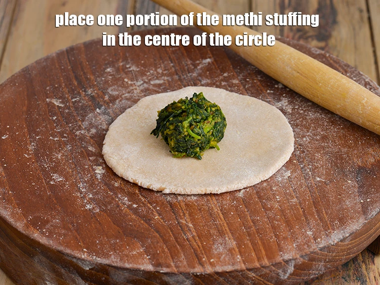 Step 16 – <p><span style="background-color:rgb(255,255,255);color:rgb(0,0,0);">Place one portion of the <strong>methi stuffing</strong> in the centre of the circle.</span></p>