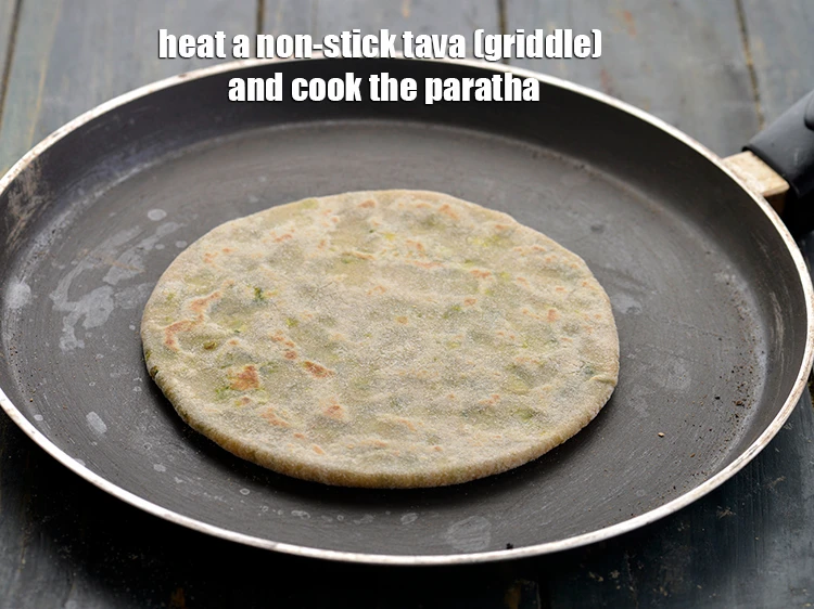 Step 19 – <p><span style="background-color:rgb(255,255,255);color:rgb(0,0,0);">Heat a non-stick tava (griddle) and cook the <strong>paratha</strong>. When lightly cooked, flip the …