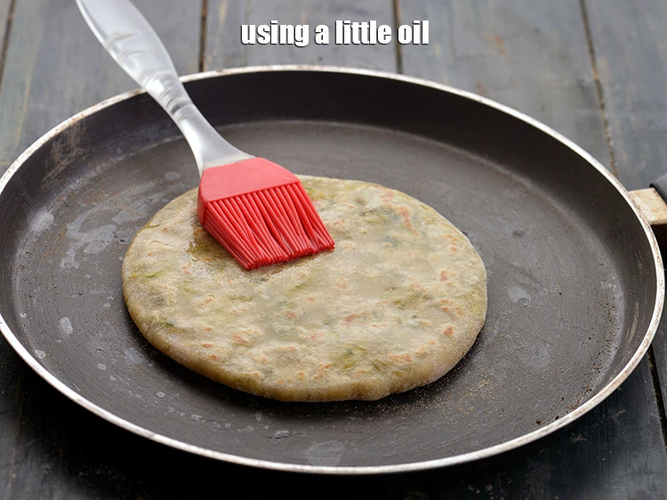 Step 20 – <p><span style="background-color:rgb(255,255,255);color:rgb(0,0,0);">Smear oil over it. Let the </span><strong>paratha</strong><span style="background-color:rgb(255,255,255);color:rgb(0,0,0);"> cook.</span></p>