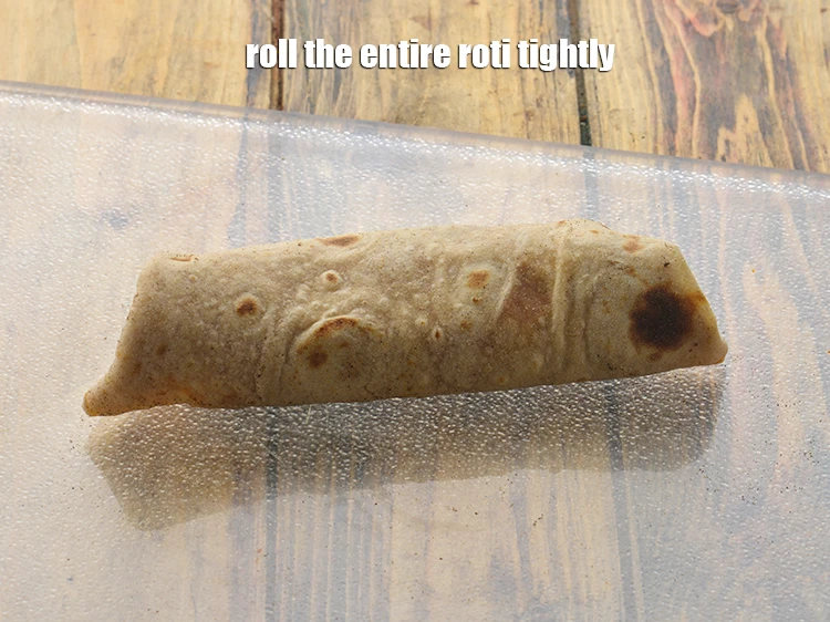 Step 27 – <p>Start rolling the roti from one open end and over the 2 folded sides. Roll …