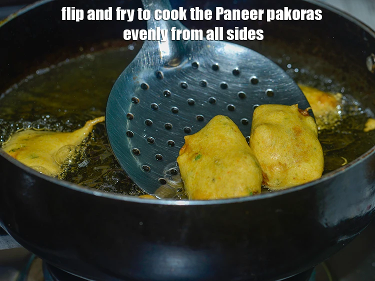 Step 29 – <p>Flip and fry to cook the <strong>Paneer pakoras</strong> evenly from all sides.</p>