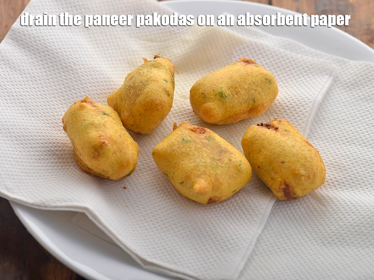 Step 30 – <p>Remove the <strong>Paneer pakoras</strong> using a slotted spoon and drain on absorbent paper to remove …