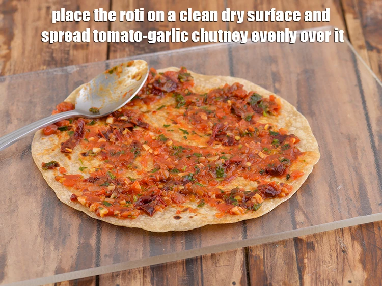 Step 41 – <p>Place the <strong>roti</strong> on a clean dry surface and spread 2 tbsp of the <a …