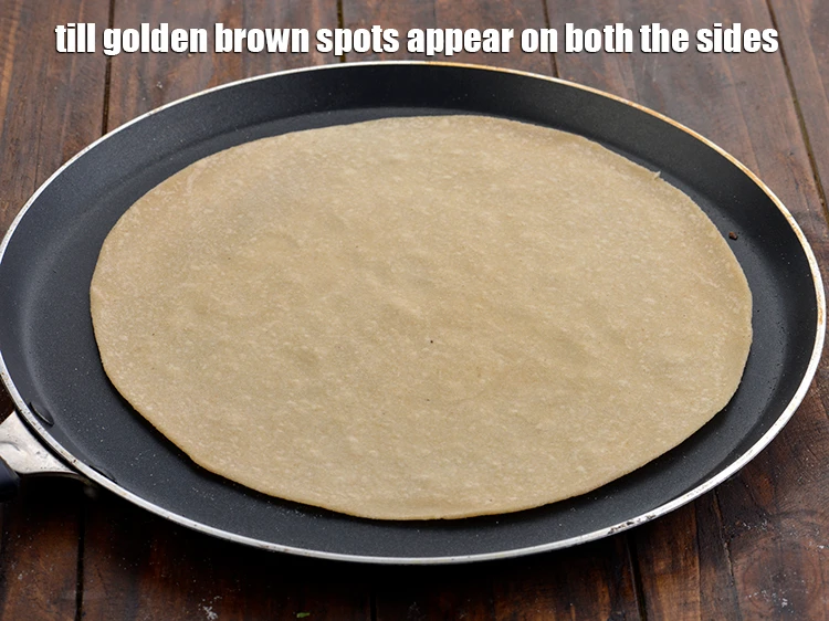 Step 14 – <p>Cook till small blisters appear on the surface. Turn over the roti and cook for …