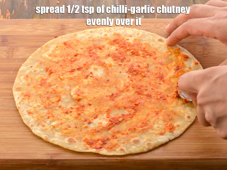 Step 47 – <p>Now spread 1/2 tsp of <a href="https://www.tarladalal.com/chilli-garlic-chutney--wraps-and-rolls-32641r"><u>chilli-garlic chutney</u></a> evenly over it. This will give a …