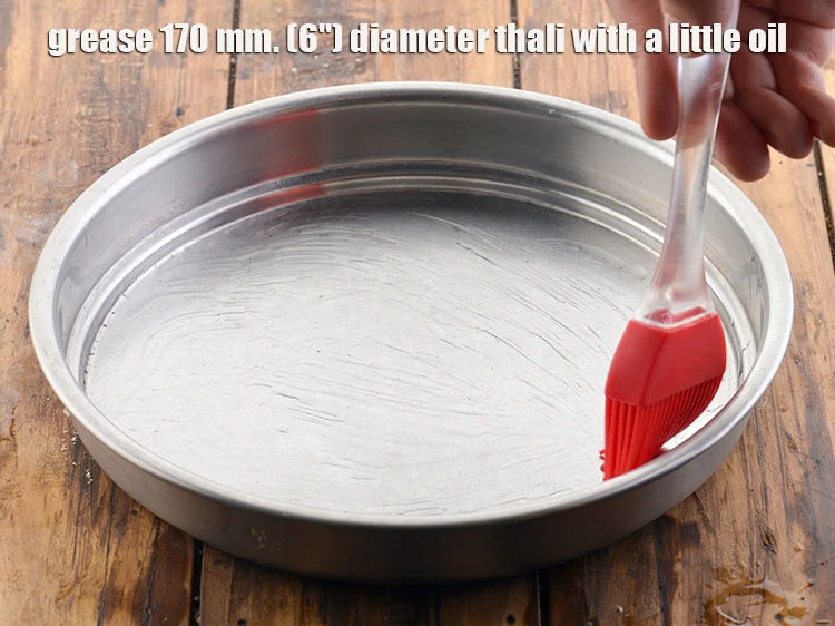Step 5 – <p><strong>Grease</strong><span style="background-color:rgb(255,255,255);color:rgb(0,0,0);"> 170 mm. (6") diameter thali with a little </span><a href="https://www.tarladalal.com/glossary-oil-671i"><u>oil</u></a><span style="background-color:rgb(255,255,255);color:rgb(0,0,0);">.</span></p>