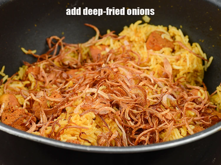 Step 45 – <p><span style="background-color:rgb(255,255,255);color:rgb(0,0,0);">Add the 1/2 cup deep-fried </span><a href="https://www.tarladalal.com/glossary-onions-pyaz-pyaaz-kanda-548i#ing_2342"><u>sliced onions</u></a><span style="background-color:rgb(255,255,255);color:rgb(0,0,0);">.</span></p>
