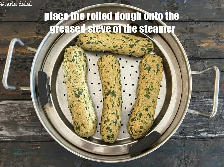 Step 21 – <p>Place the rolled dough&nbsp;on a greased sieve of a steamer. This will prevent the muthia …