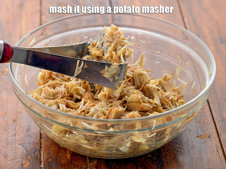 Step 6 – <p>Transfer the <strong>jackfruit</strong> in a deep bowl and <strong>mash</strong> it using a potato masher.</p>