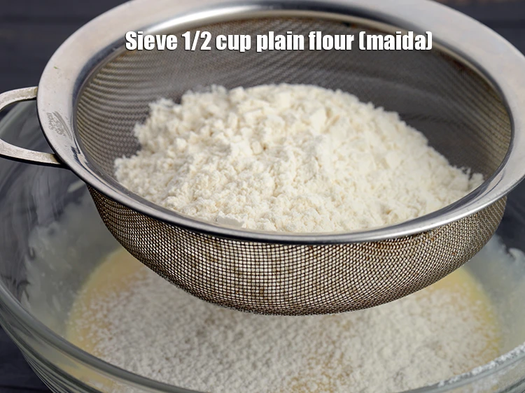 Step 5 – <p>Add sieve 1/2 cup <a href="https://www.tarladalal.com/glossary-plain-flour-maida-188i"><u>plain flour (maida)</u></a>.</p>