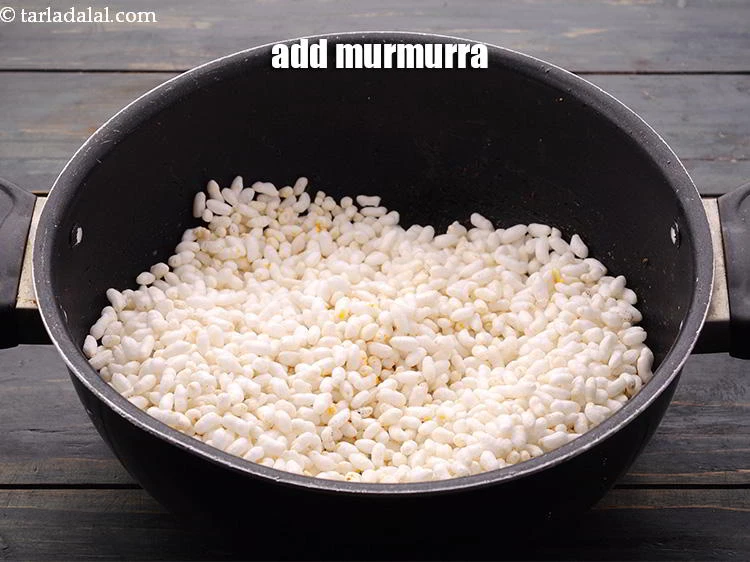 Step 15 – <p>Switch on the flame, add the <a href="https://www.tarladalal.com/glossary-puffed-rice-kurmura-murmura-mamra-537i#ing_2452">murmurra</a>.</p>